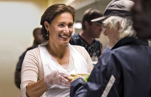 woman handing tray of food to a man