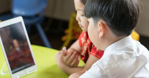 Primary-age children watch general conference on a mobile device in Suzhou, China.