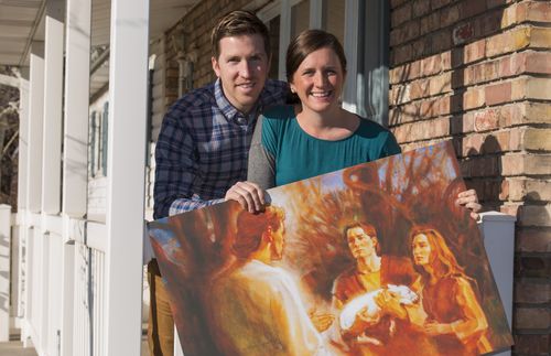 couple holding Adam and Eve painting