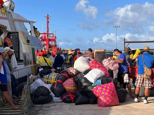 boat dock with volunteers and donated supplies