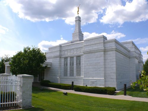 A side view of the Detroit Michigan Temple on a sunny day, with green lawns and a blue sky.