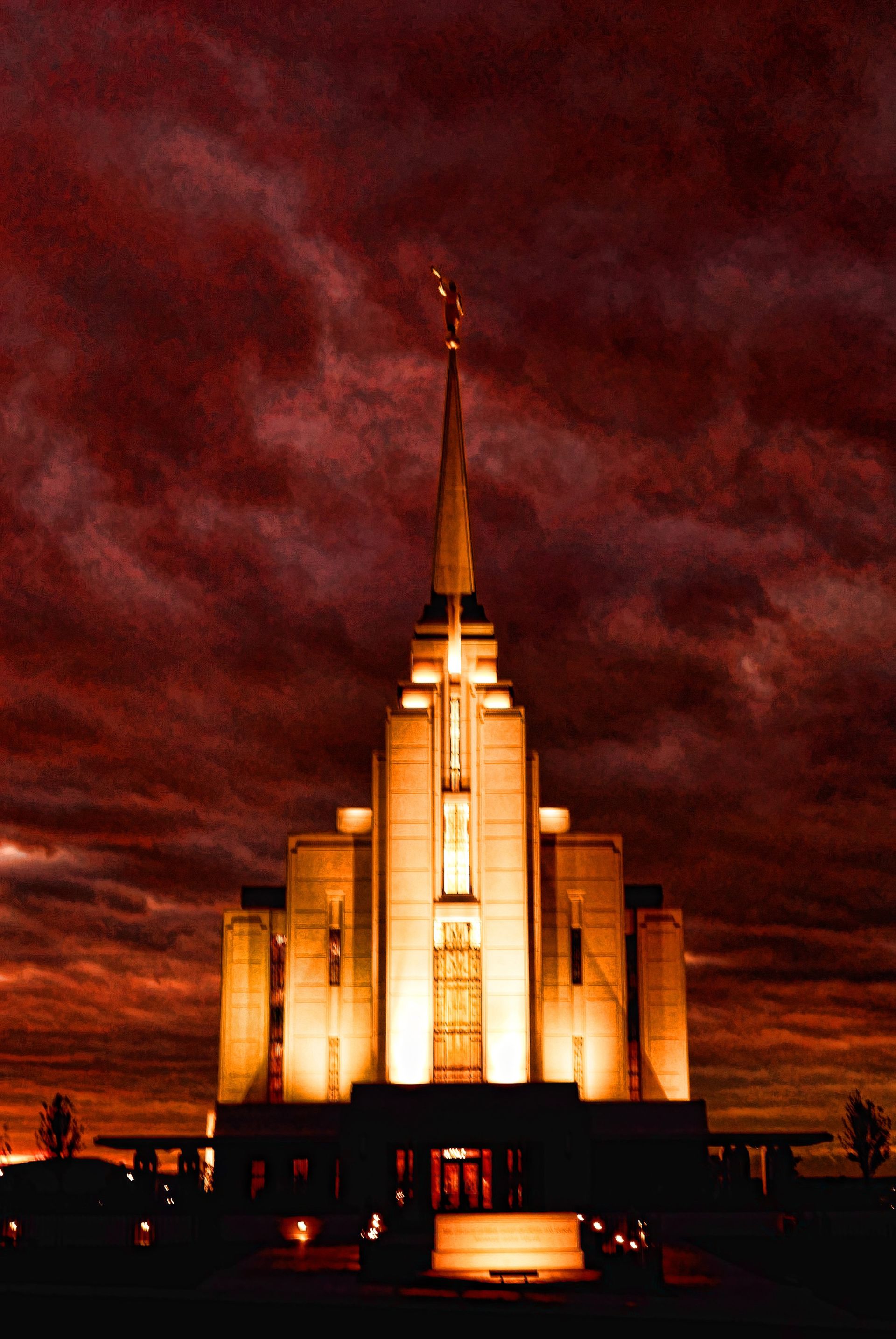 The Rexburg Idaho Temple in the evening during a storm, including the name sign.