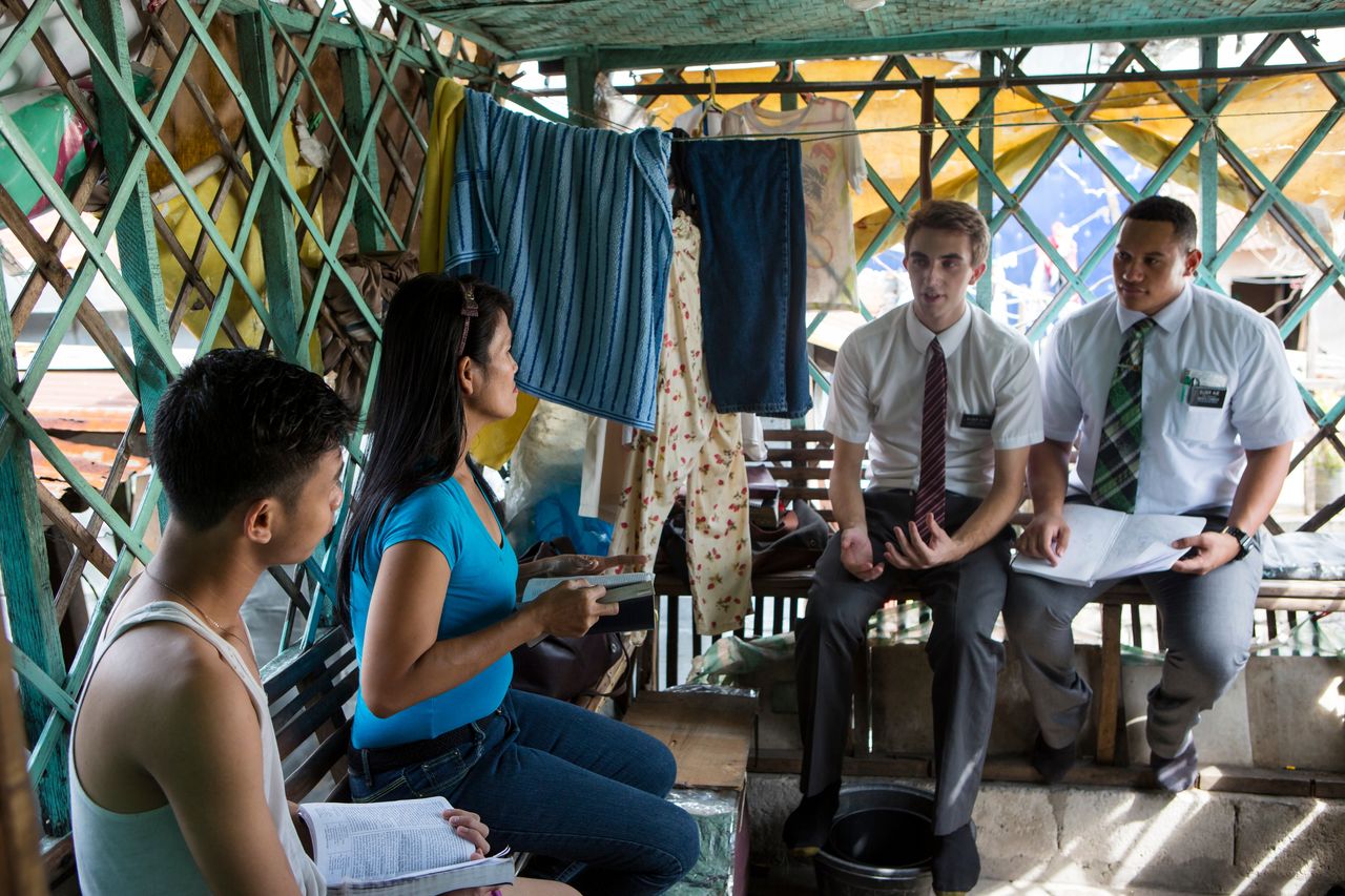 Missionaries teach a family in their home