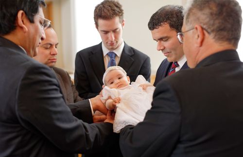 män som välsignar ett spädbarn