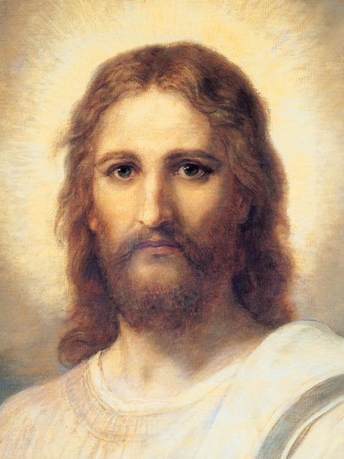 Frontal head and shoulders portrait of Jesus Christ. Christ is depicted wearing a pale red robe with a white and blue shawl over one shoulder. Light emanates from His face.