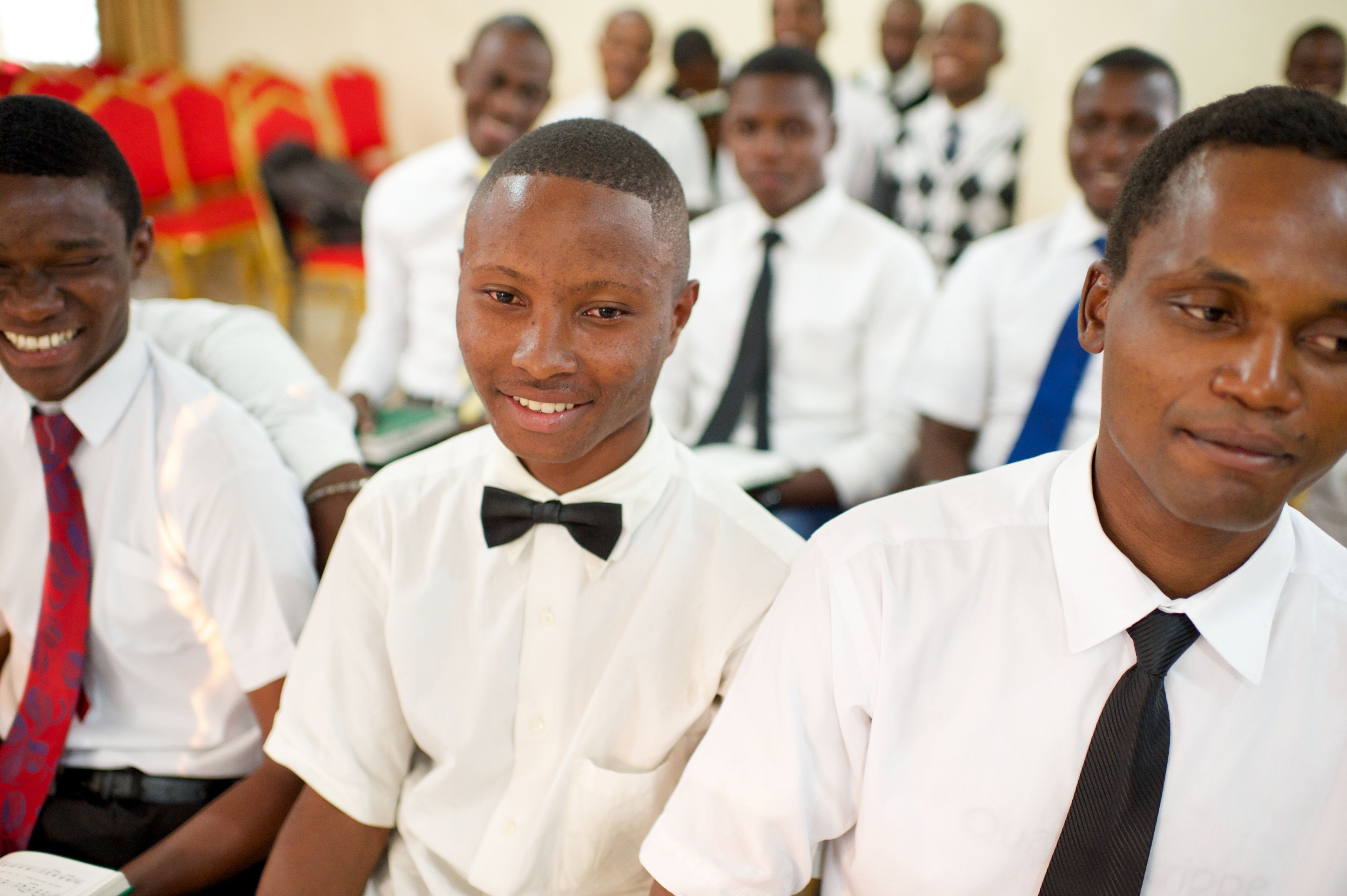 Young men from Africa sit in rows at church.