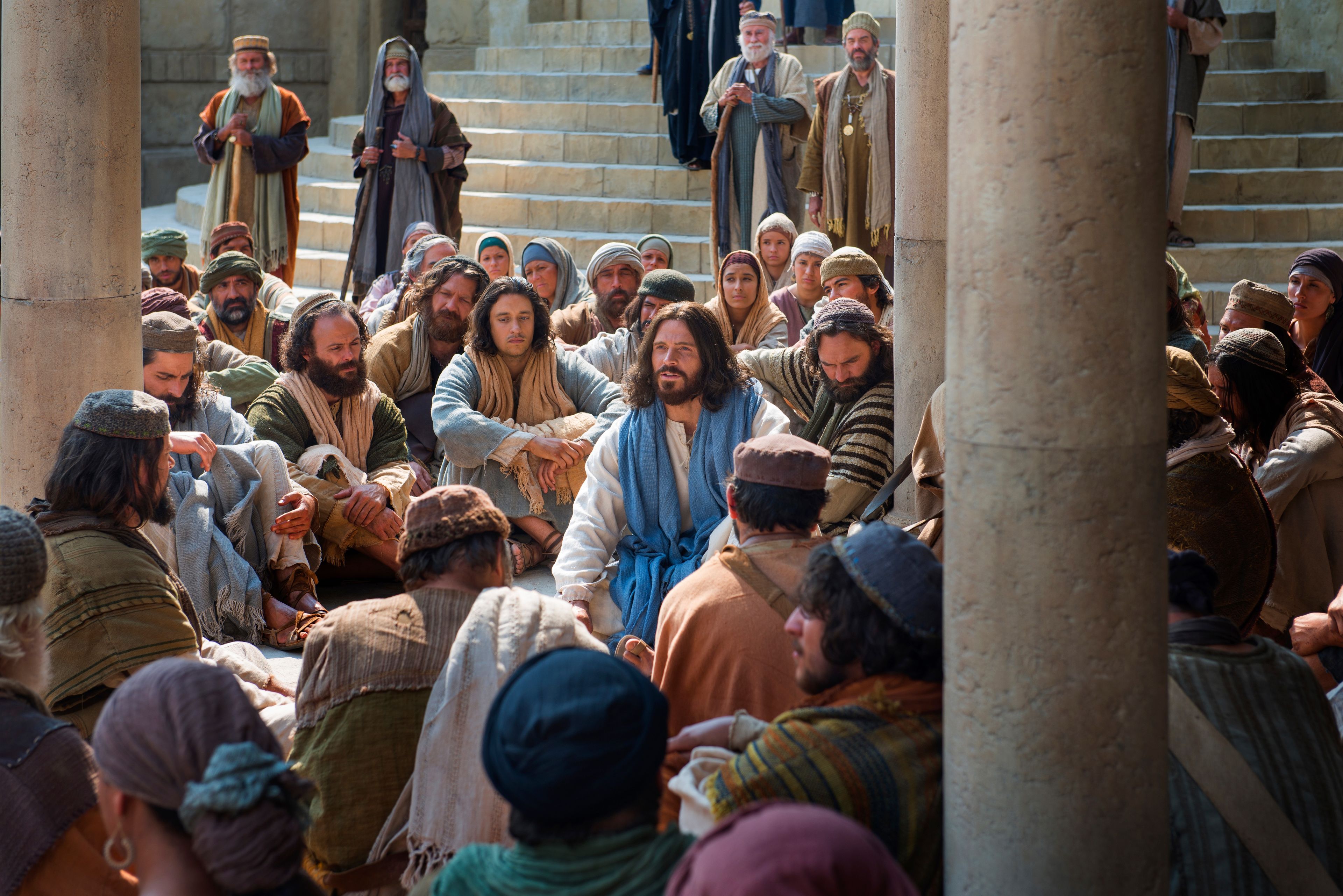 Jesus sits in the midst of a group of people and tells them of the greatest commandment.
