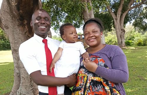 author standing outside with his wife and daughter