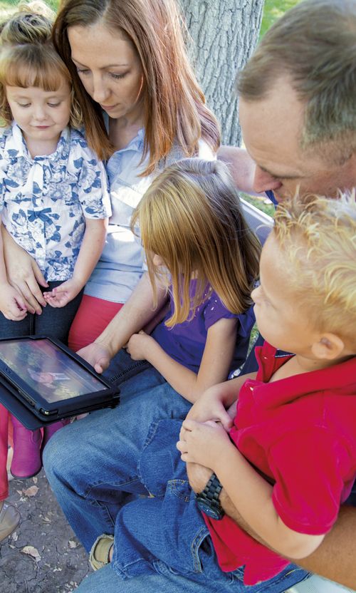 family watching general conference on a tablet