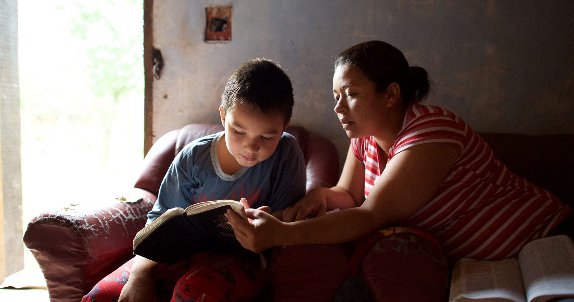 Mother and son sitting together and reading the scriptures.