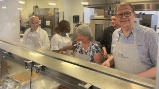 Volunteers serve dinner in cafeteria