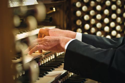 The hands of an organist are shown playing the organ at the Salt Lake Tabernacle.