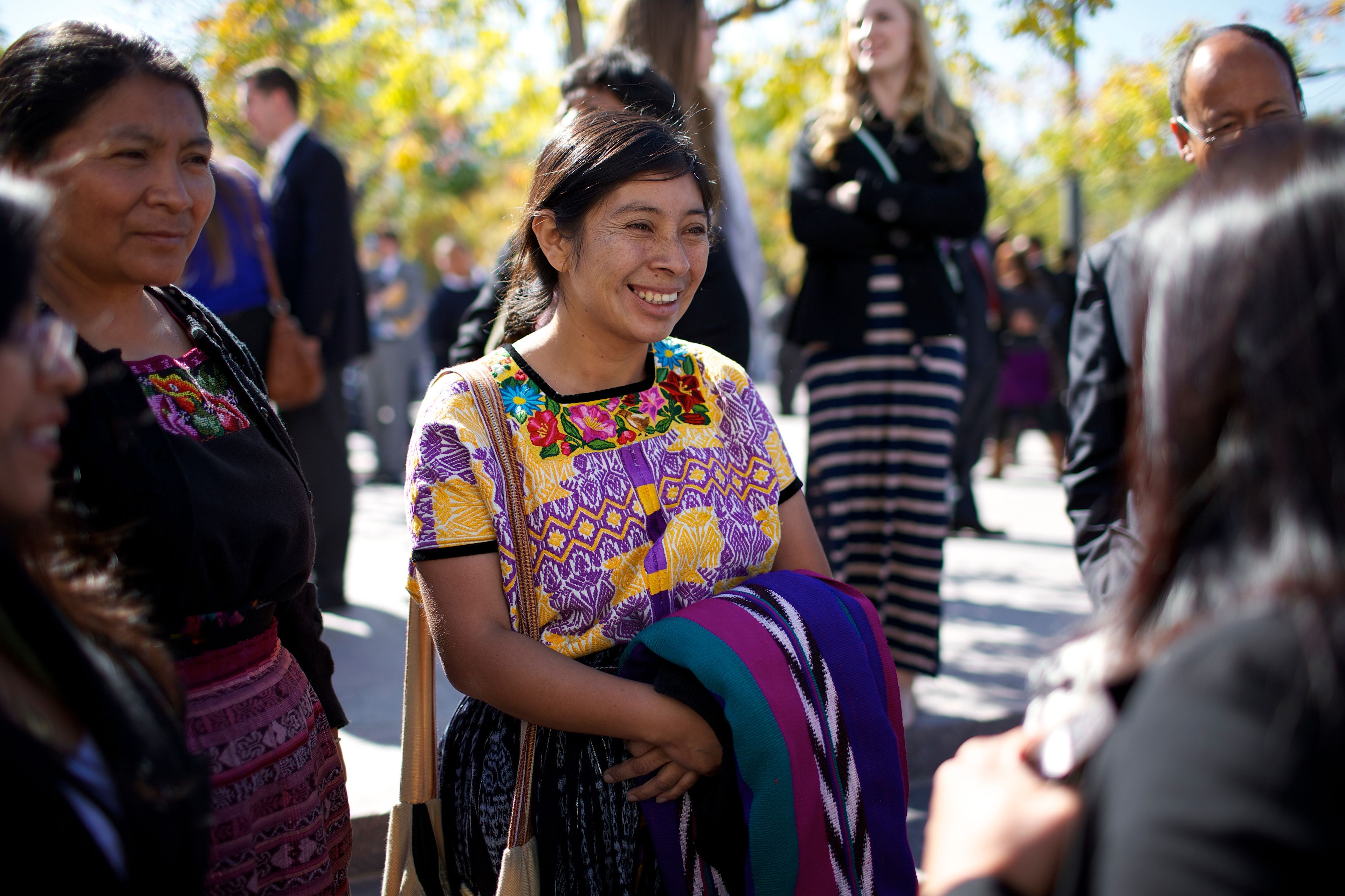 Two women standing outside of the Conference Center, talking to another woman.