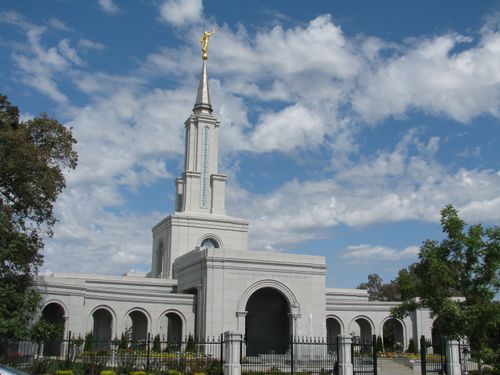 The entrance of the Sacramento California Temple, with a view of the spire and arches on either side of the doors.