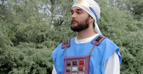 A man dressed in the costume of a High Priest at the model of the Jewish Tabernacle.