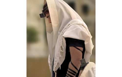 Combined image of two men wearing phylacteries and an image of the wailing wall in Jerusalem