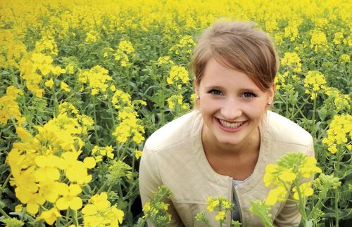 Photo of a young adult woman, Esther Graf, in a field of flowers in Germany.