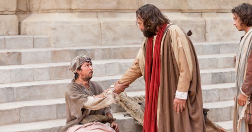 Peter reaches out his hand to a crippled man and commands him to rise and walk.