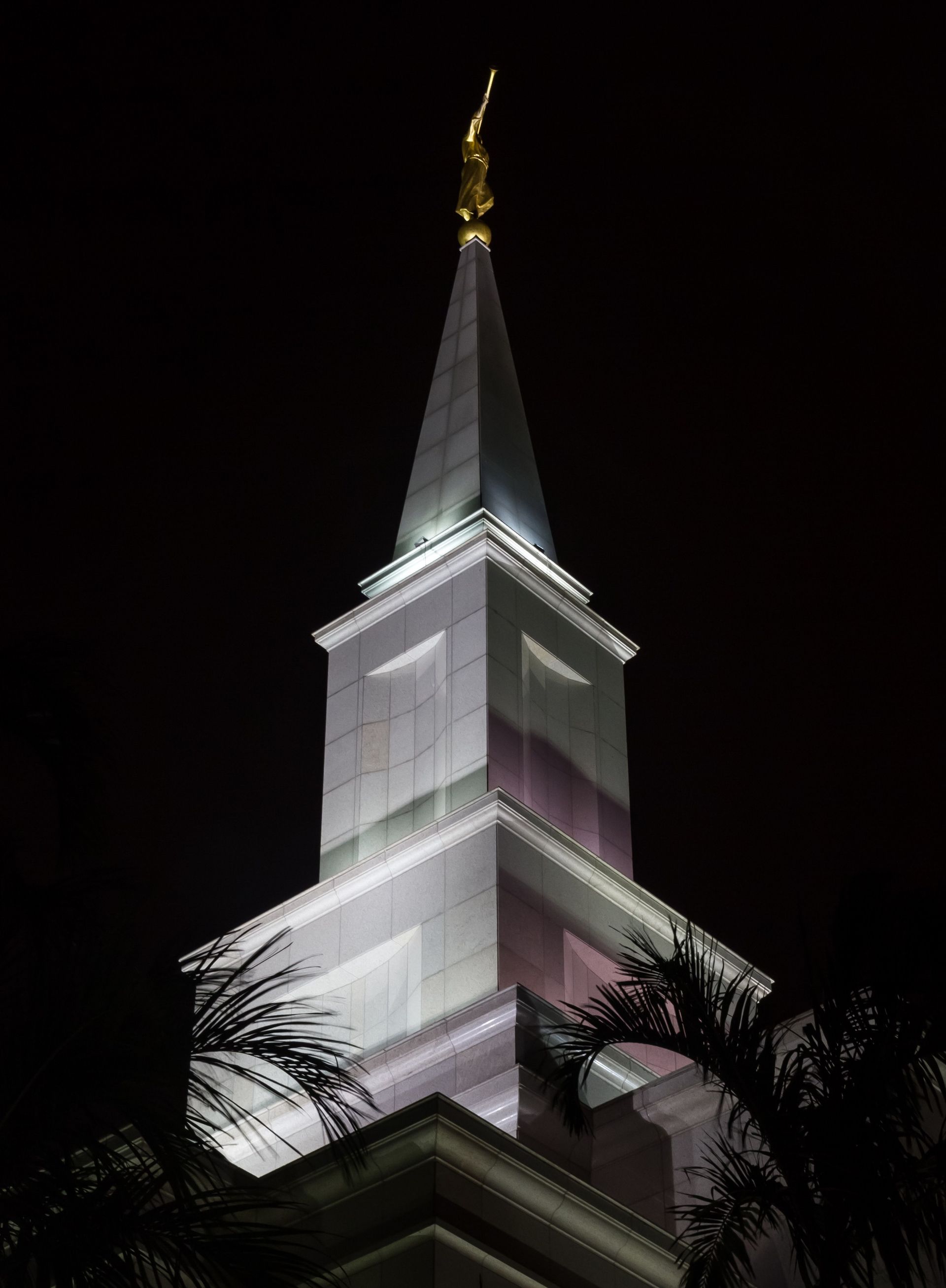 Lights shine on the spire of the Guayaquil Ecuador Temple at night.