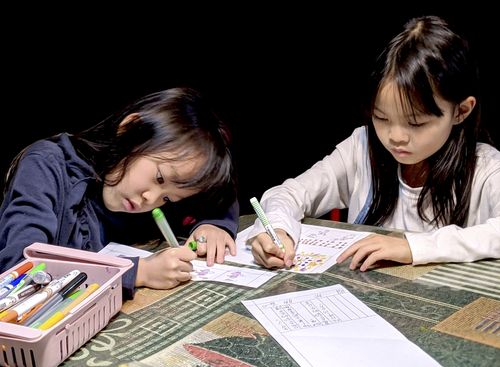 Photo of two girls drawing with markers