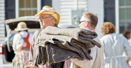 man carrying blankets