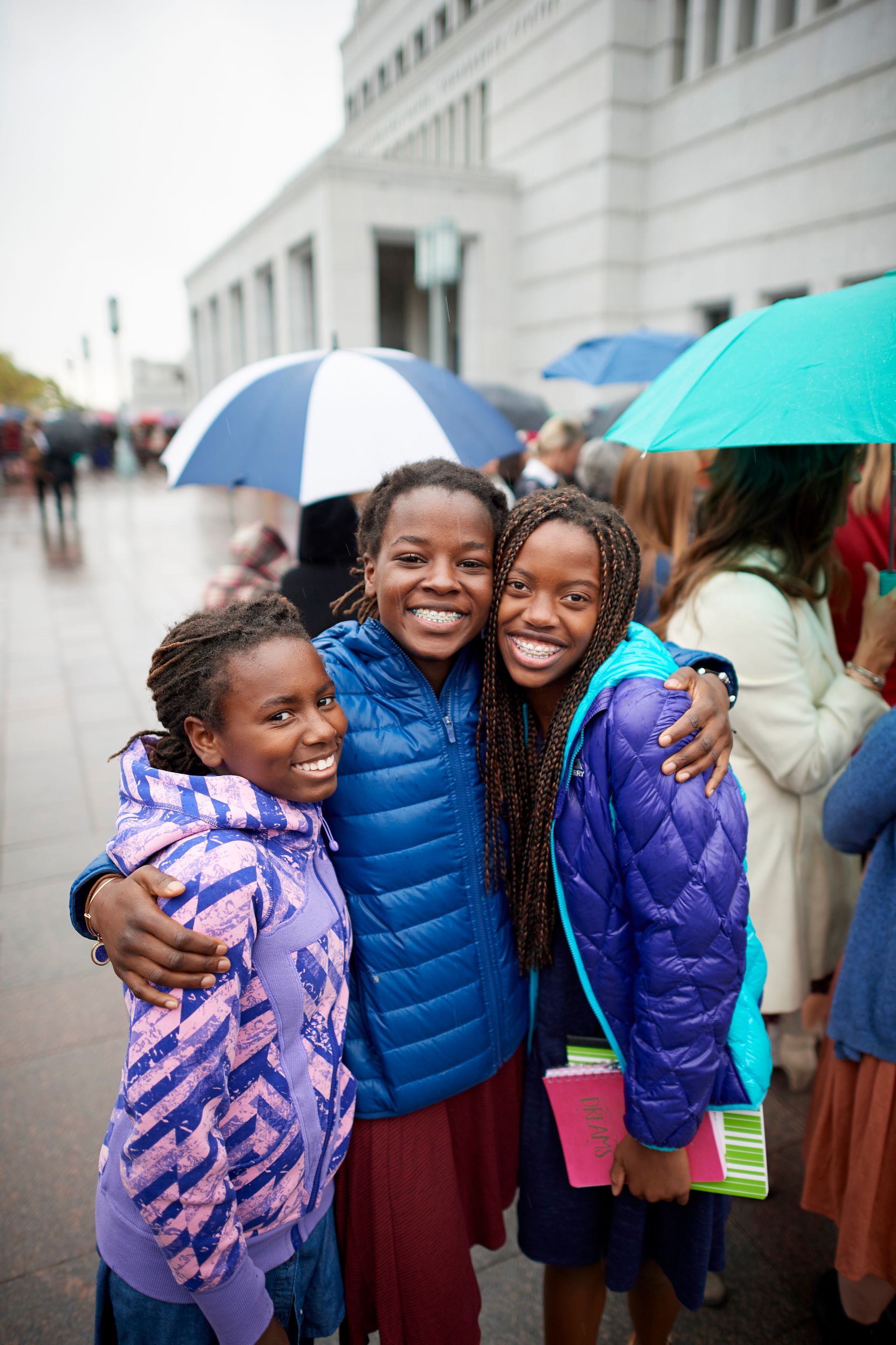 Three young women attending the general women’s session of general conference together.