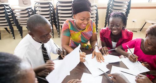 group of people smiling and writing