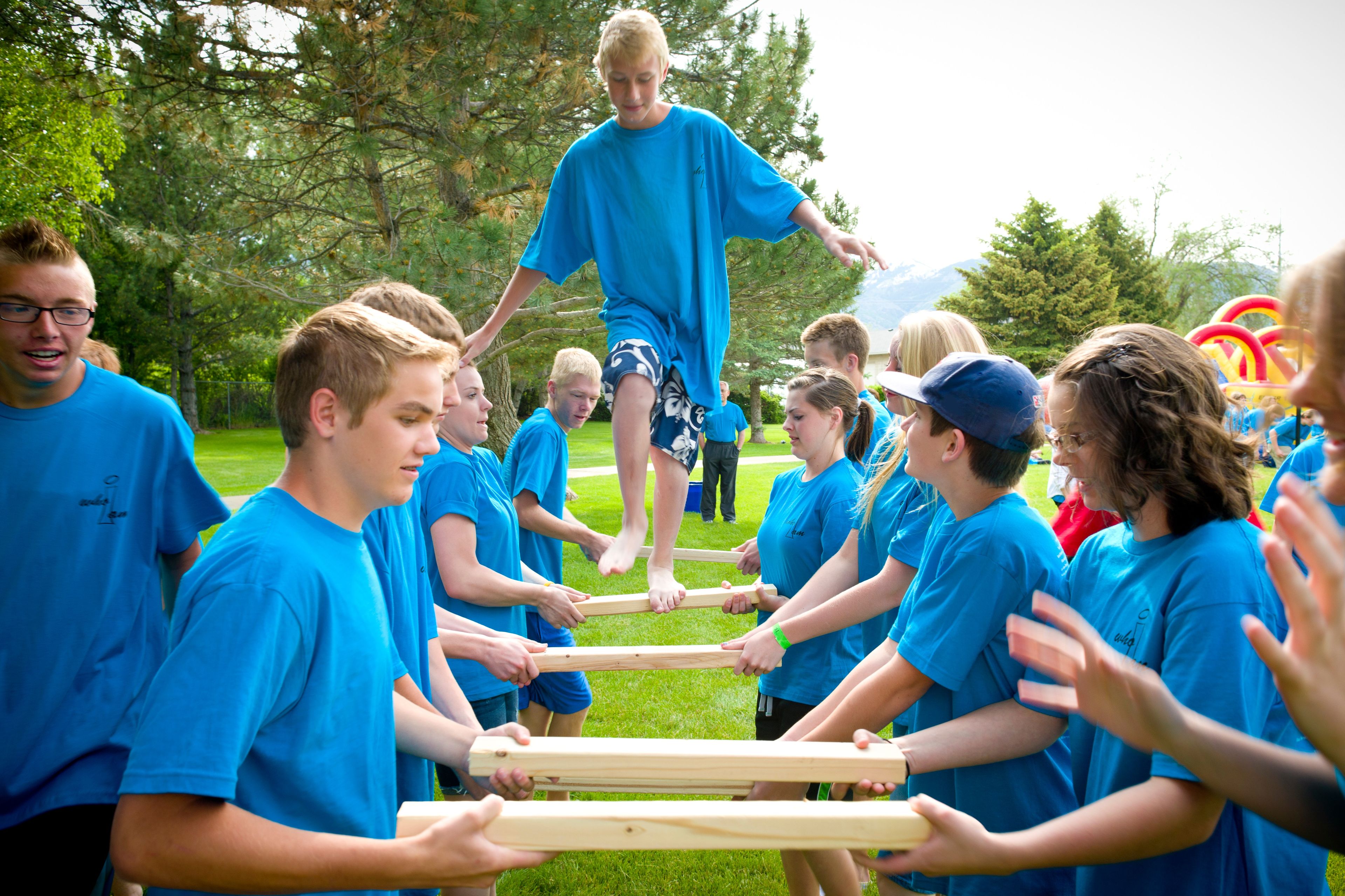 A group of youth line up and do a trust activity.