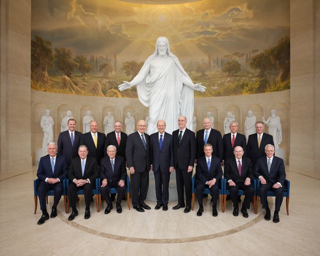 All the members of the First Presidency and the Quorum of the Twelve Apostles are seated or standing with the Christus Statue and statues of the Original Twelve at the Visitors' Center in Rome, Italy.  Front Left to Right: Dieter F. Uchtdorf, Jeffrey R. Holland, M. Russell Ballard, Dallin H. Oaks, Russell M. Nelson, Henry B. Eyring, David A. Bednar, Quentin L. Cook, D. Todd Christofferson, Gary E. Stevenson, Ronald A. Rasband, Neil L. Andersen, Dale G. Renlund, Gerrit W. Gong, Ulisses Soares