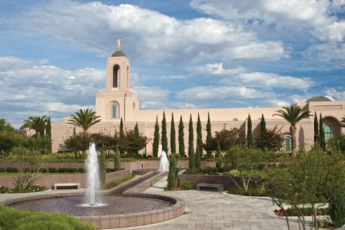 The fountains on the grounds of the Newport Beach California Temple, with the temple seen in the background beyond green trees.