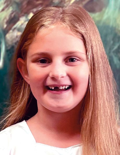 Headshot of smiling girl in white shirt