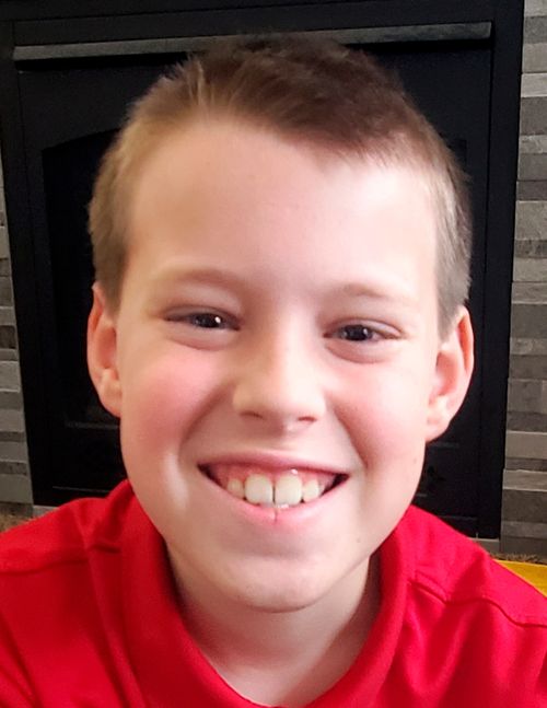 Headshot of smiling boy in red shirt