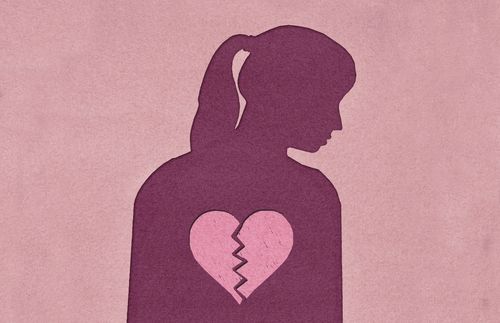 silhouette of woman with image of broken heart