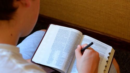 student marking scriptures on paper