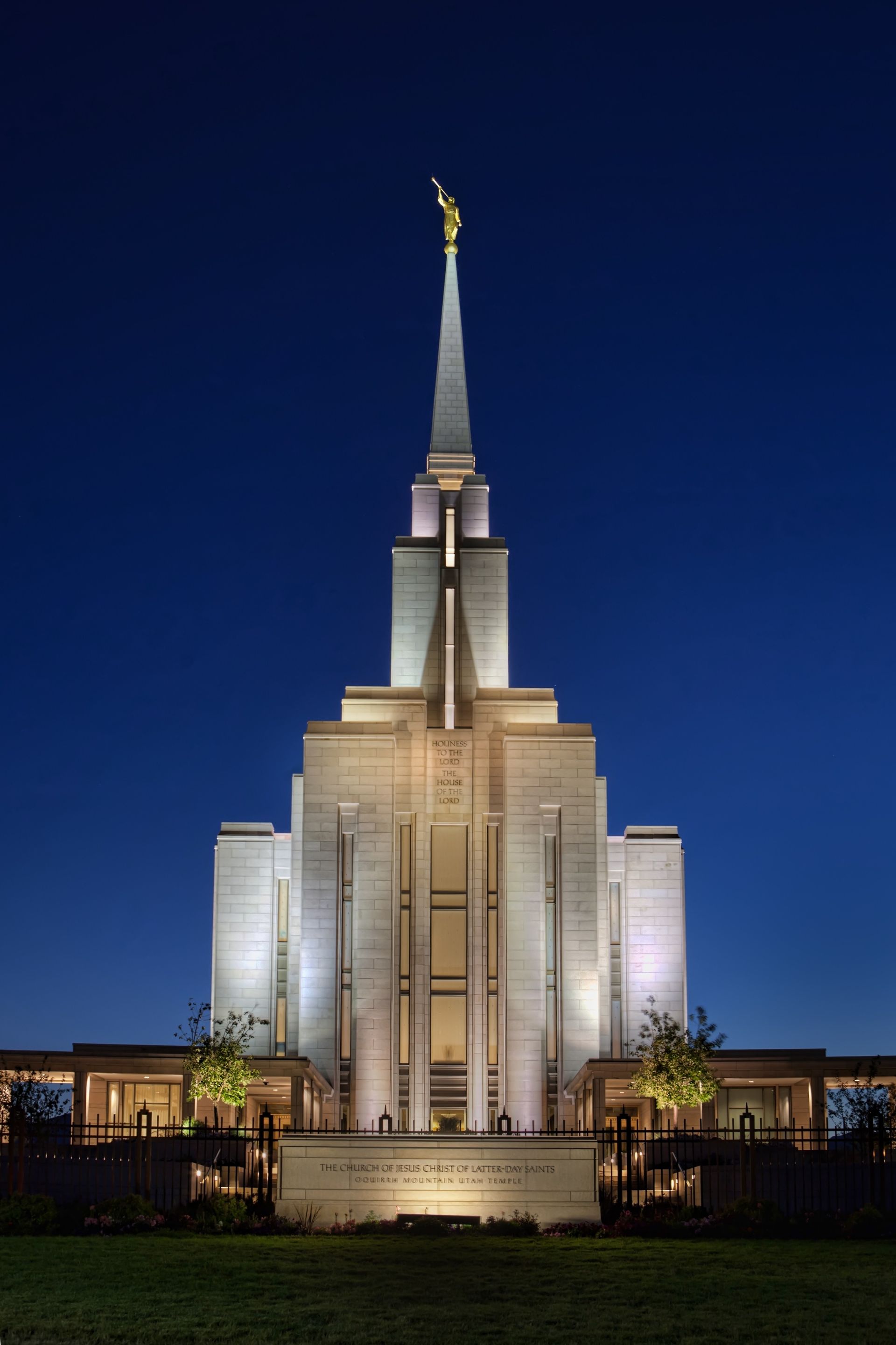The Oquirrh Mountain Utah Temple in the evening, including the name sign and entrance.
