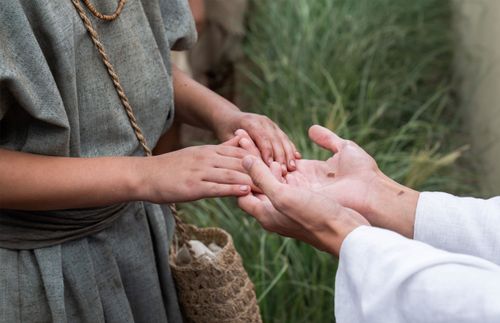 follower touching the hands of the resurrected Savior