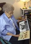 Elderly woman looking at photo album.