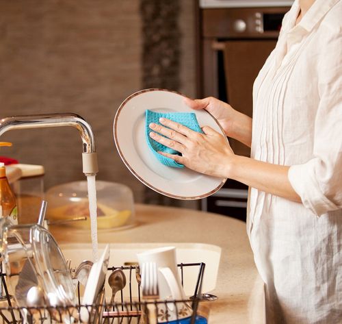 una mujer lavando la vajilla