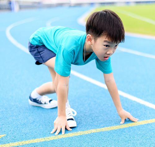 un niño preparándose para correr