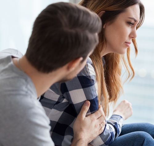 man comforting discouraged woman