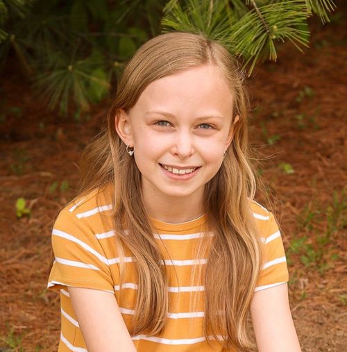 A photo of Emmeline McKeown wearing a striped shirt and a big smile.