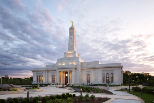A side view of the Indianapolis Indiana Temple and its surrounding landscape at sunset.