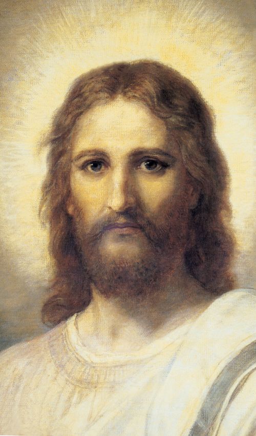 Frontal head and shoulders portrait of Jesus Christ. Christ is depicted wearing a pale red robe with a white and blue shawl over one shoulder. Light emanates from the face.