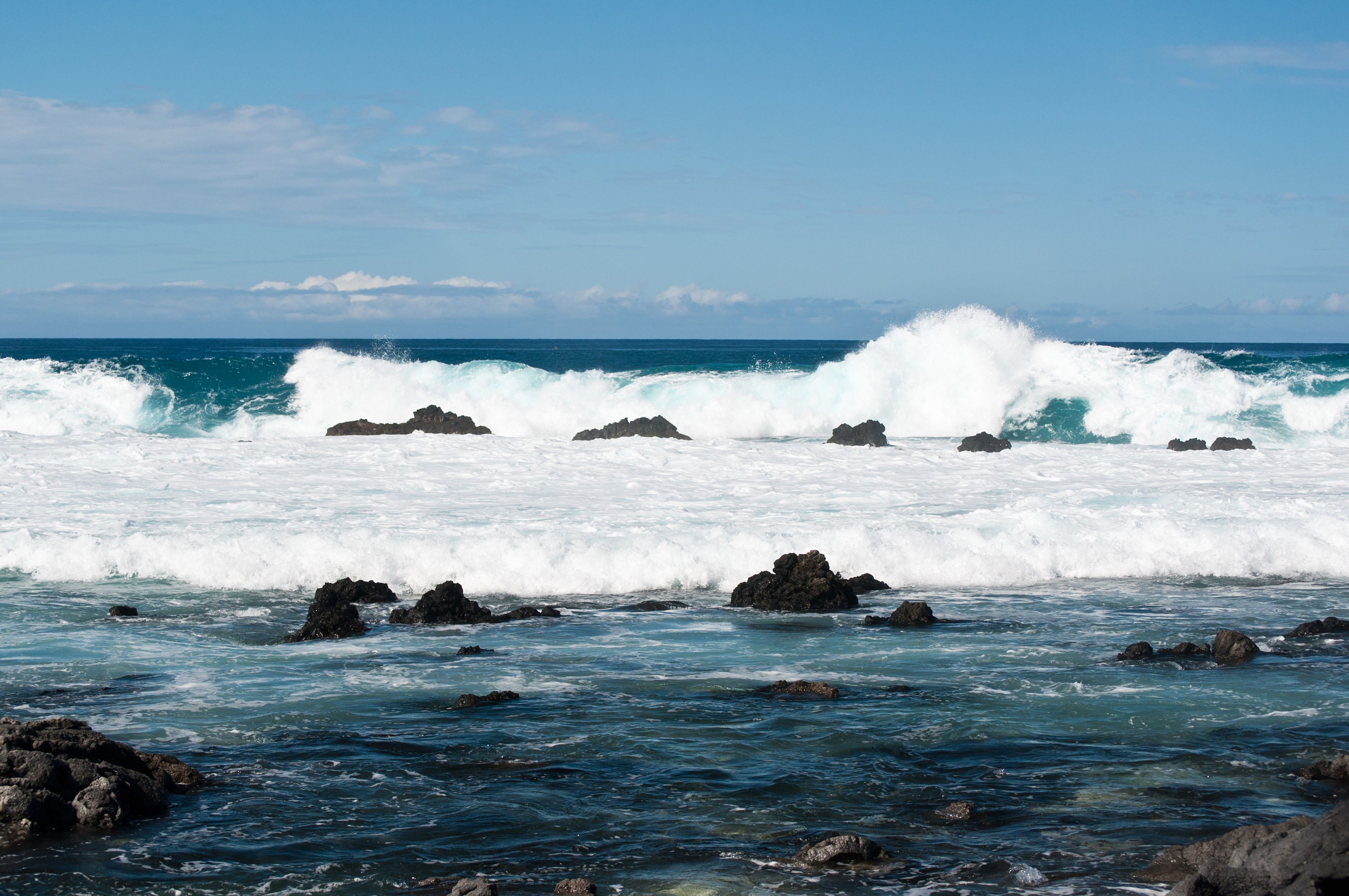 Rocks rise above the waterline in Hawaii.