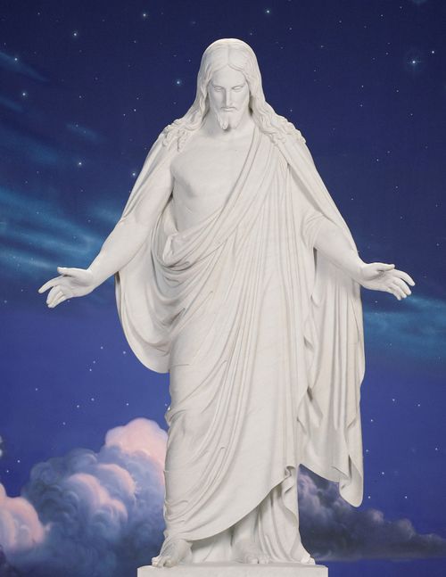 A statue of Jesus Christ against a painted backdrop resembling the night sky.