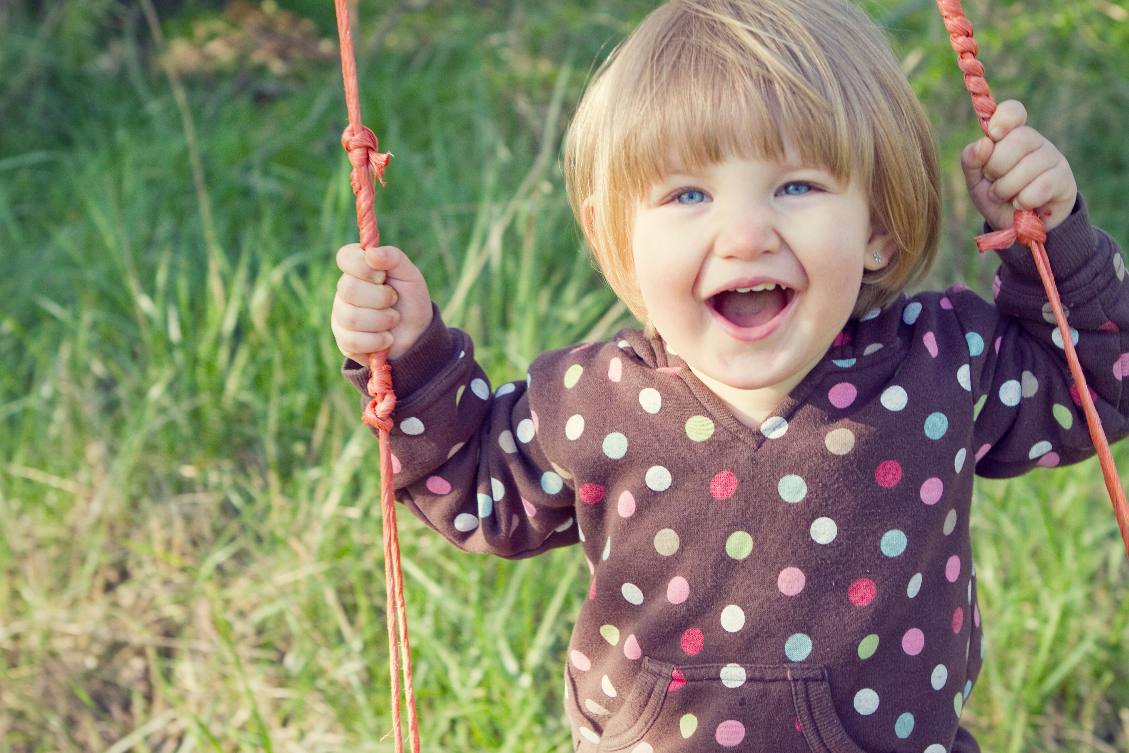 A little girl plays on swings.