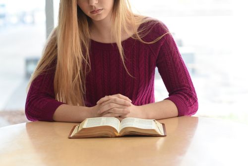 eine Frau liest in den heiligen Schriften