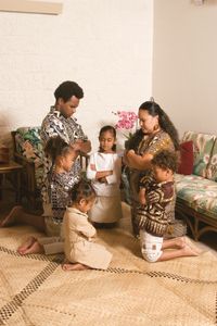 A Polynesian family kneeling in prayer.