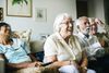 Four elderly people sitting and laughing