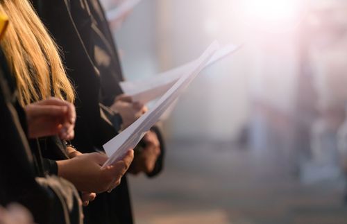 carolers holding music